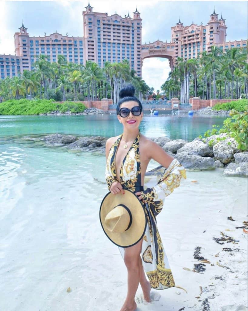 Black hair woman is standing right infront of Royal Tower in Atlantis Bahamas