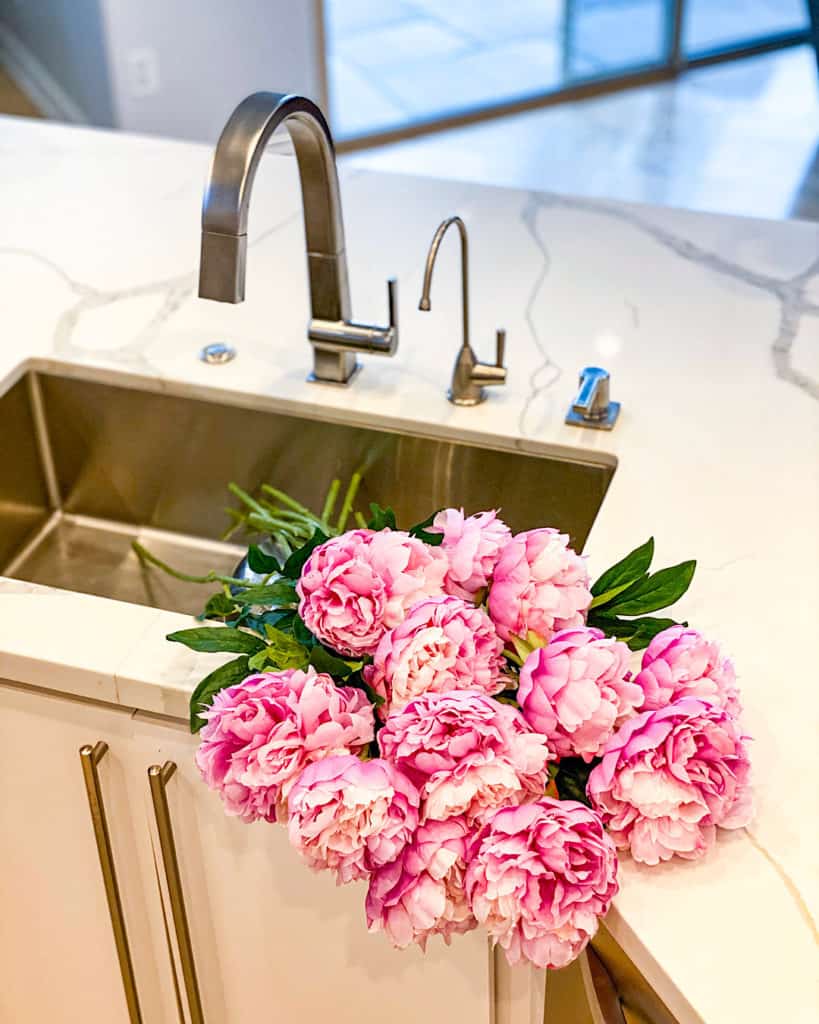 Freshly cut peonies in kitchen sink