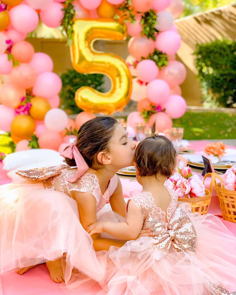 Sisters embrace in beautiful dresses at lockdown birthday party at home