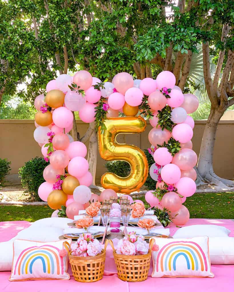 My 5 Year Old's Birthday Party at home with balloon arch, table settings and pink decorations