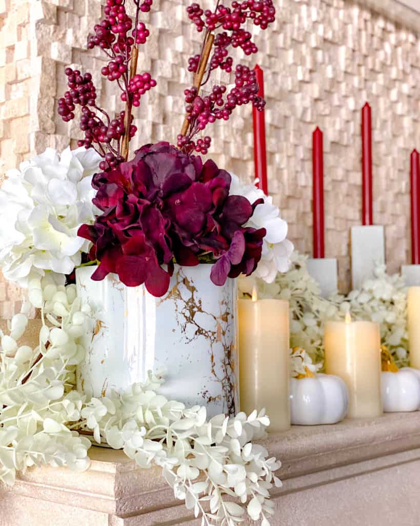 Stylish fall decor ideas: the main fireplace mantel with red candles and faux flower arrangement