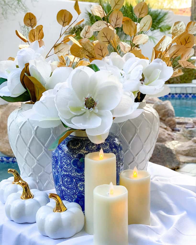 Blue and white vase, candles and pumpkins for Thanksgiving decorations