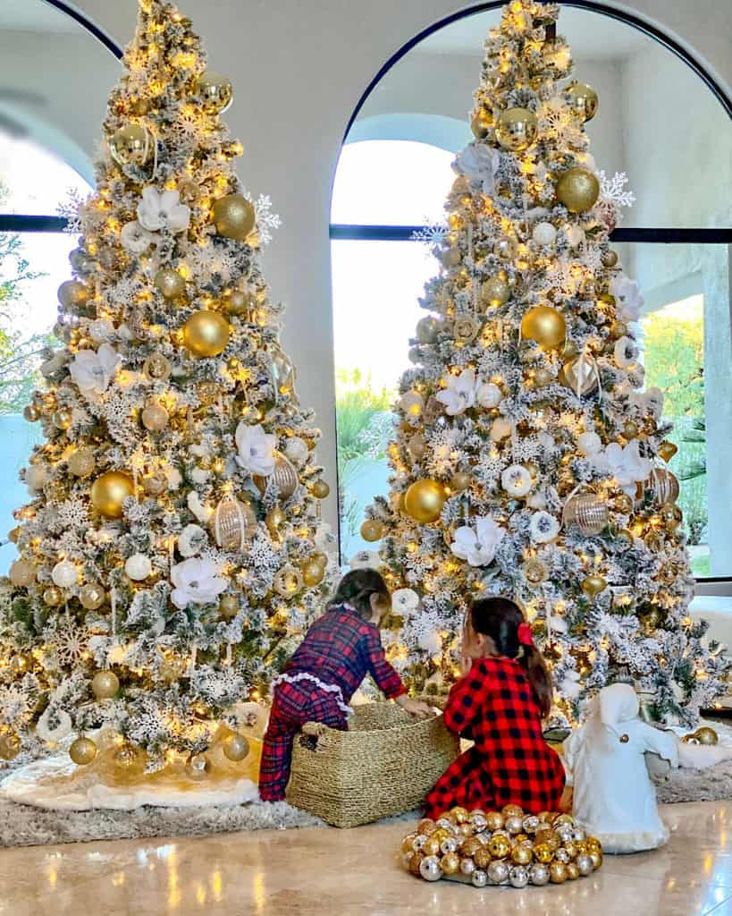 Two girls decorating White and Gold Christmas trees