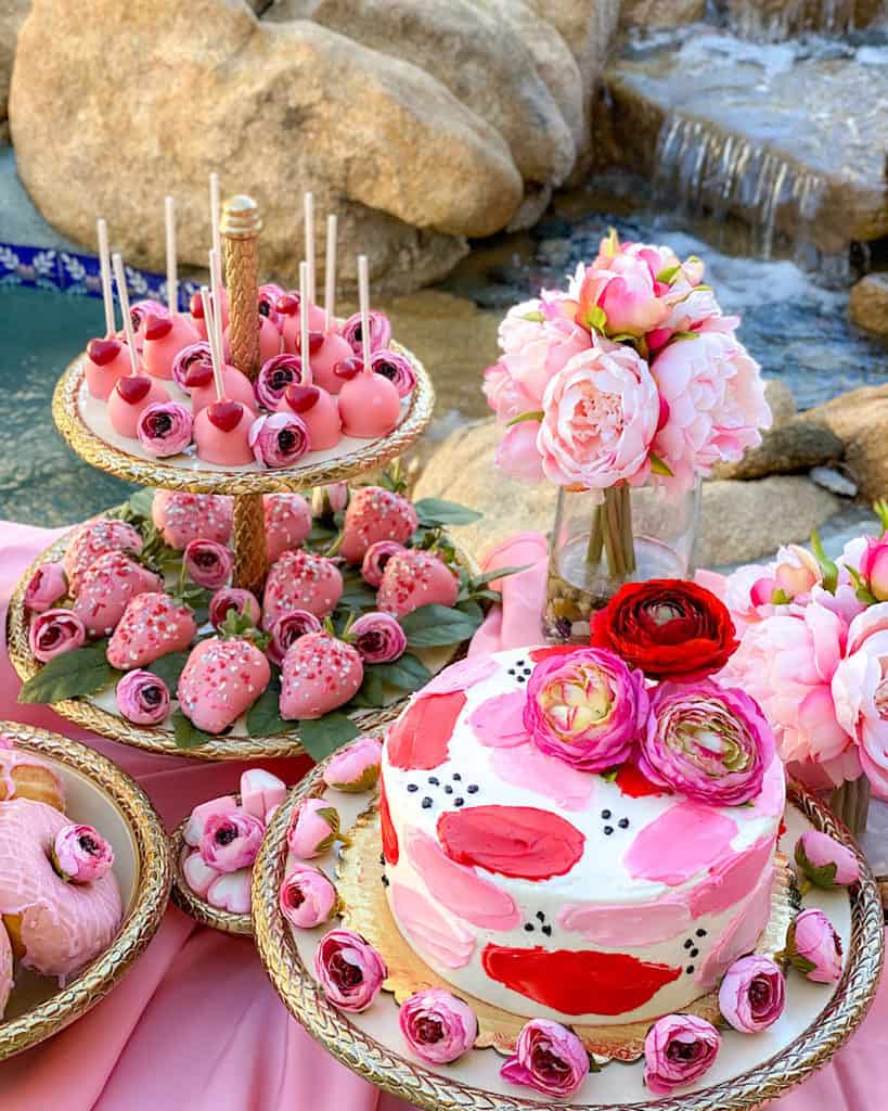 Pink, red and white Valentine’s Day cakes on a dessert Table