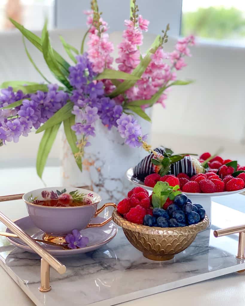 Afternoon teacup and saucer set with flowers and fresh fruits