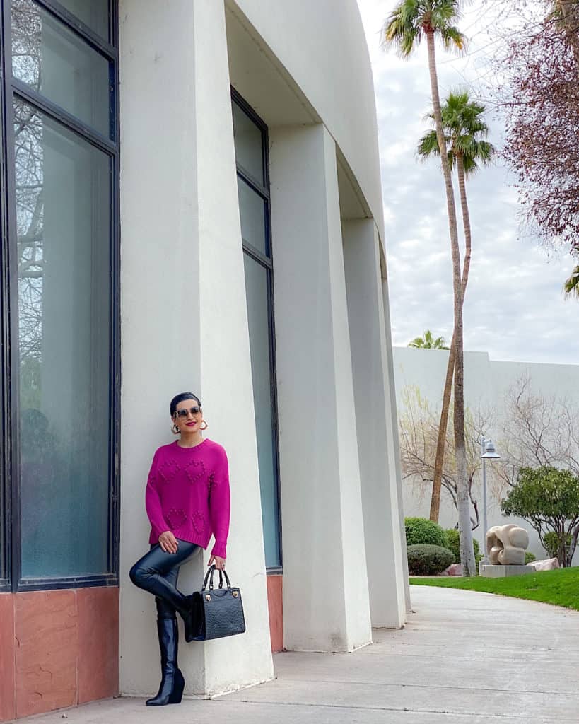 women leaning against a white pillar wearing a cute and classy outfit for Valentine's Day 