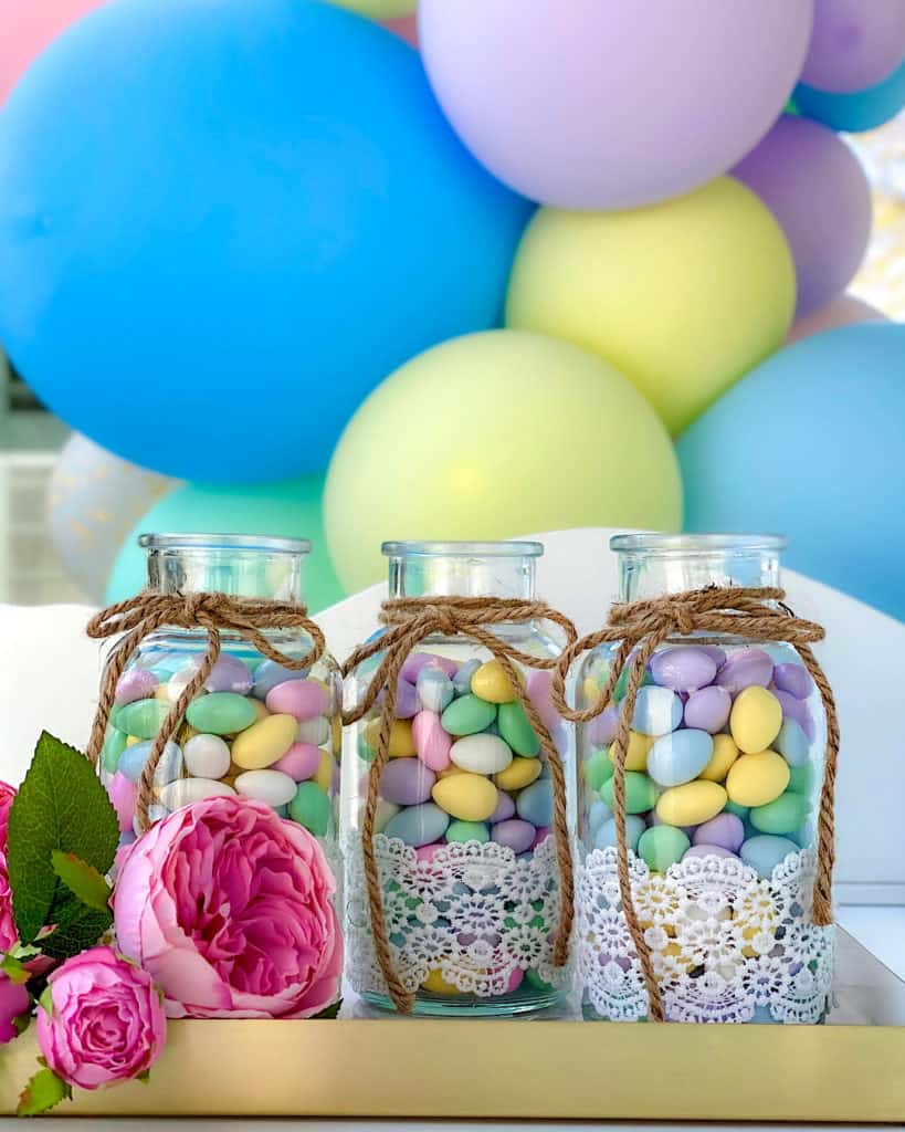 Pretty jars of candy at birthday party dessert table. 