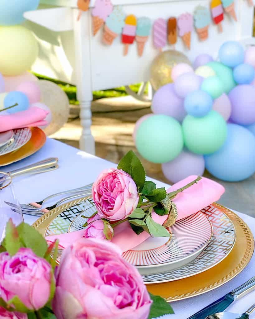 Table settings, flowers and balloons for ice cream birthday party. 