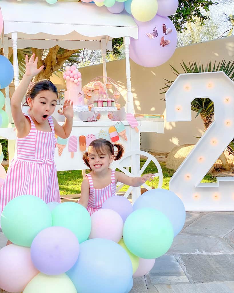 Girls playing with birthday balloons.