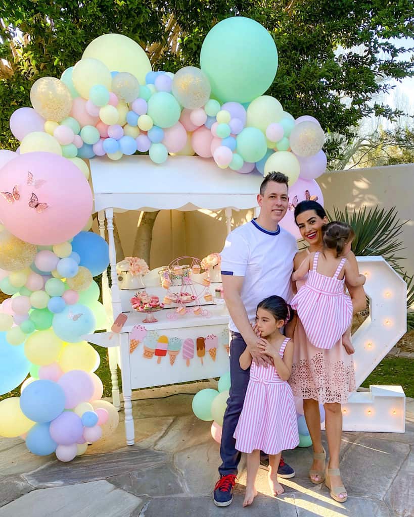 Family standing beside ice cream cart. 