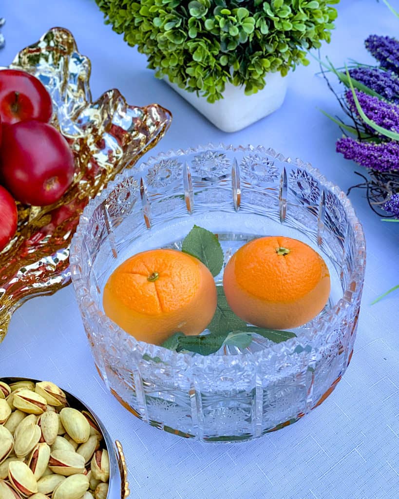 A crystal bowl of water with an orange: Nowruz table decorations