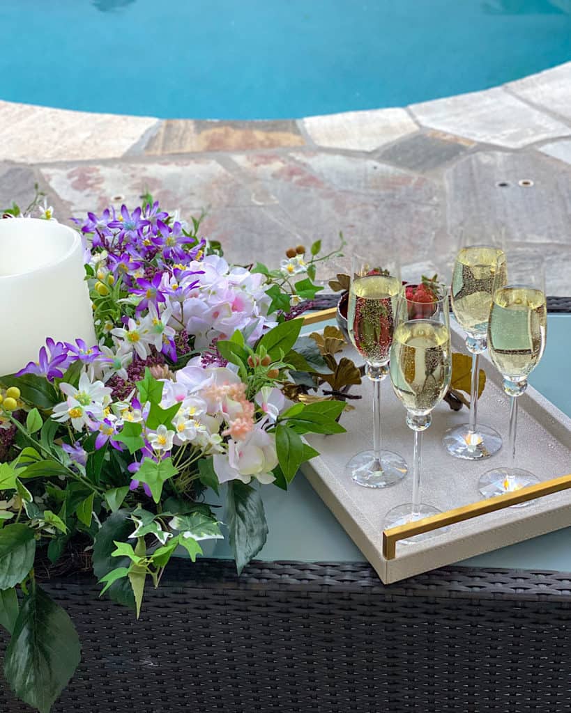 Champagne glasses on a tray with flowers. 