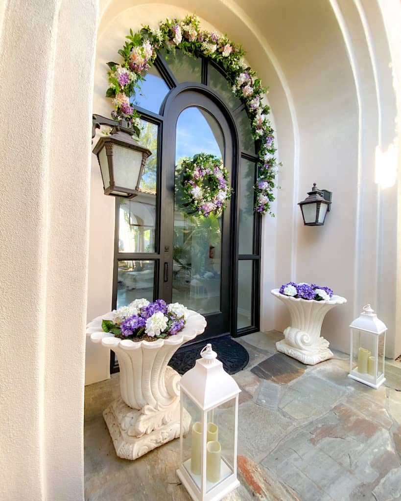 Floral displays and storm candles in a front door entranceway