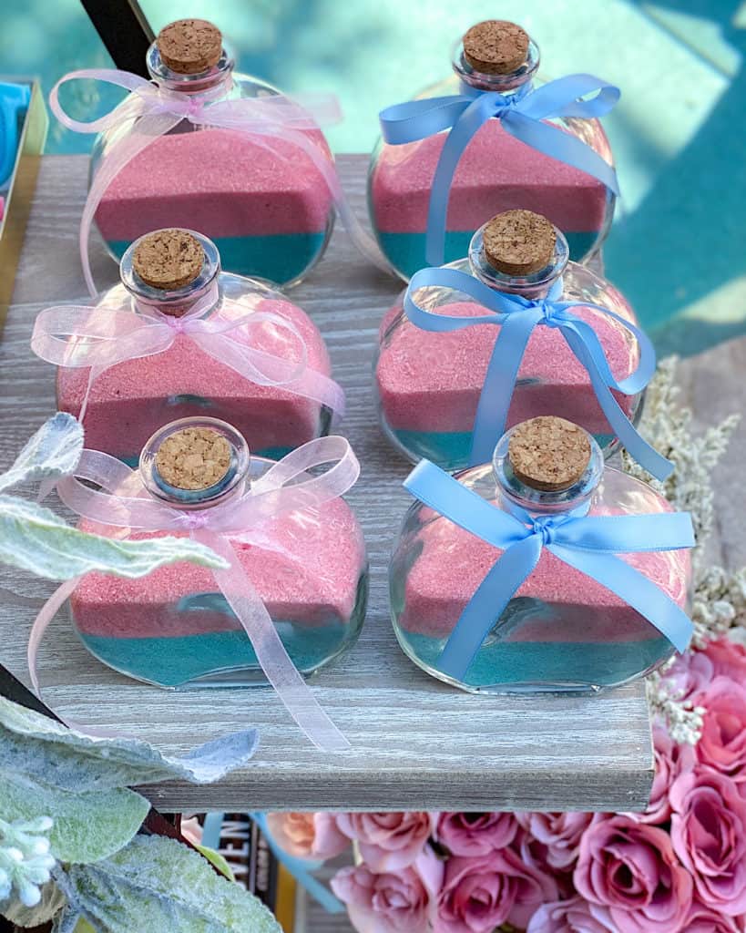 Glass bottles with pink and blue sand and ribbons