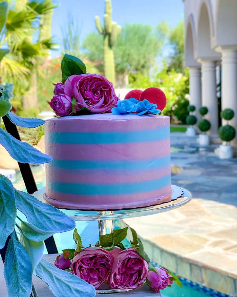 Pink and blue layer cake with pink and blue flower decorations 