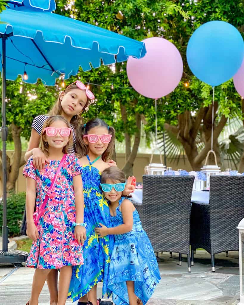 Girls in pink and red dresses at a gender reveal party