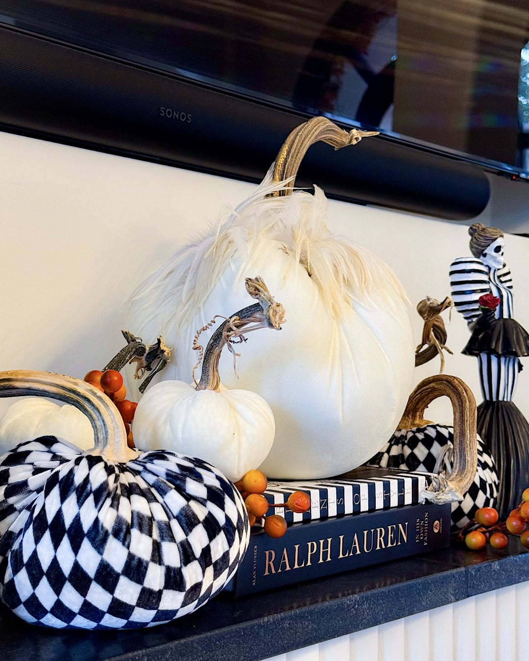 Fall Halloween mantel decor with stacked decorative books and velvet pumpkins