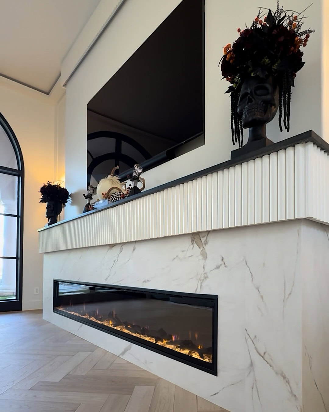 Halloween fireplace mantel decor with a black skull planter on each side
