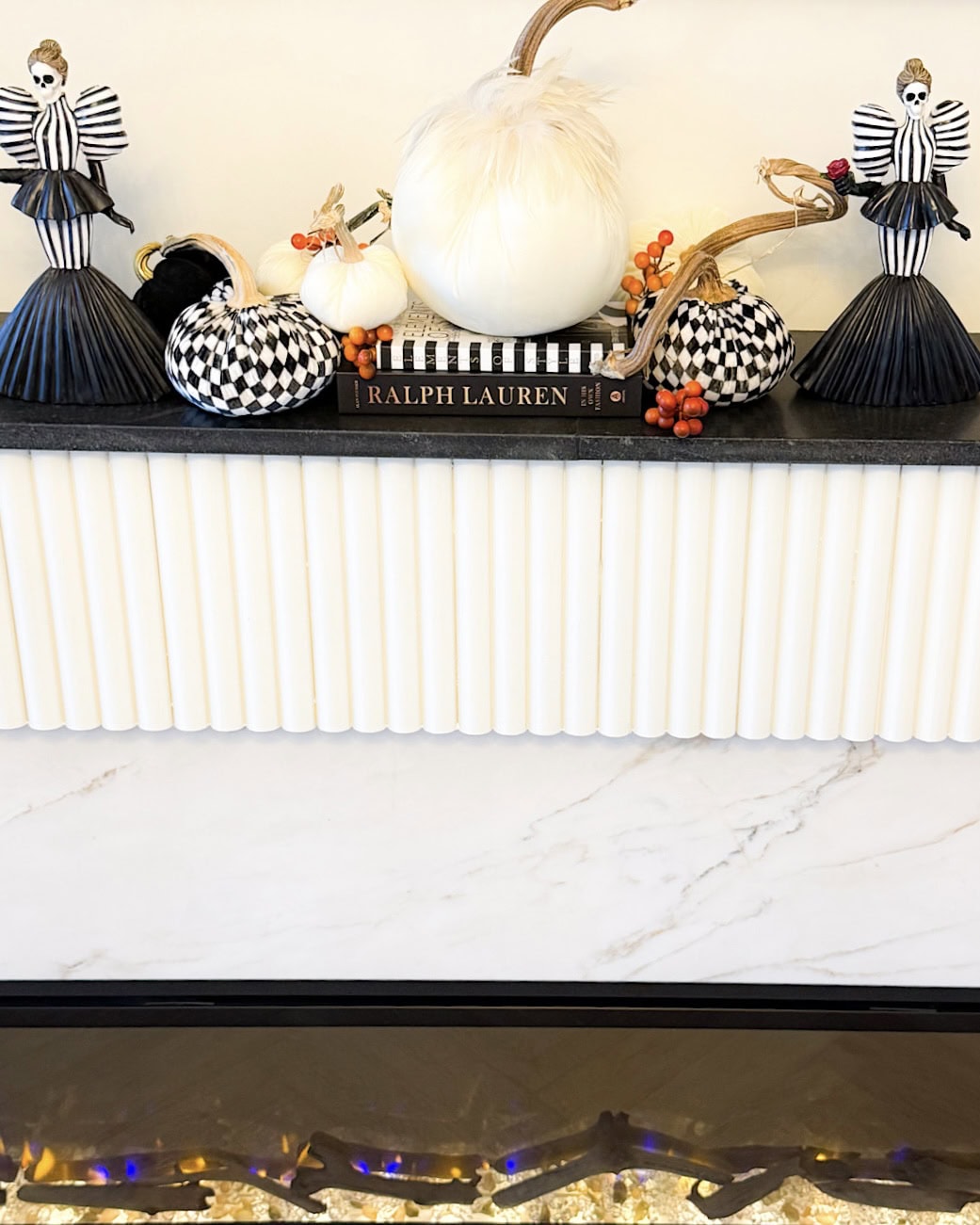 Halloween fireplace mantel ideas with orange berries tucked between pumpkins