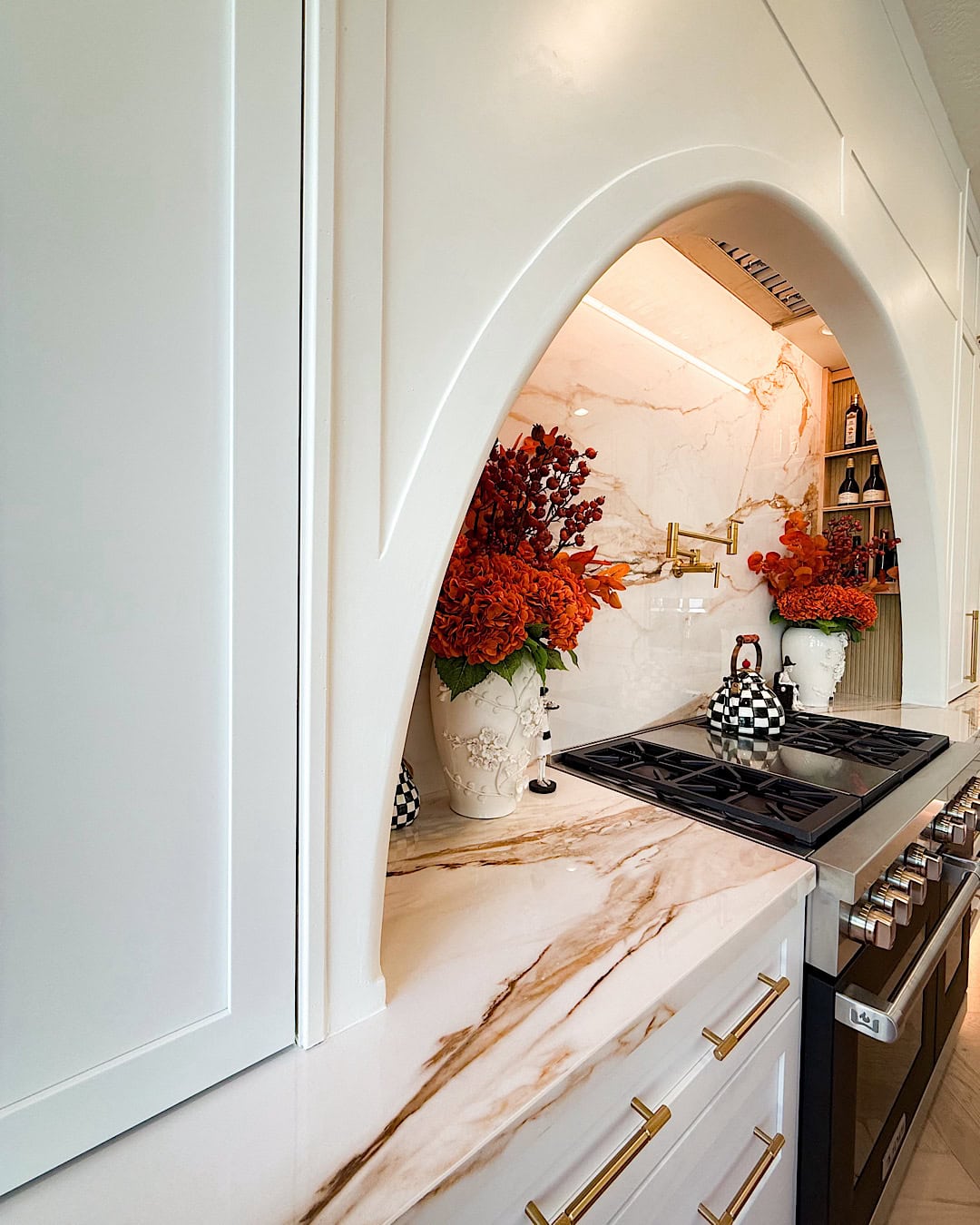 Halloween kitchen decor ideas with white vases of orange hydrangeas on each side of the range