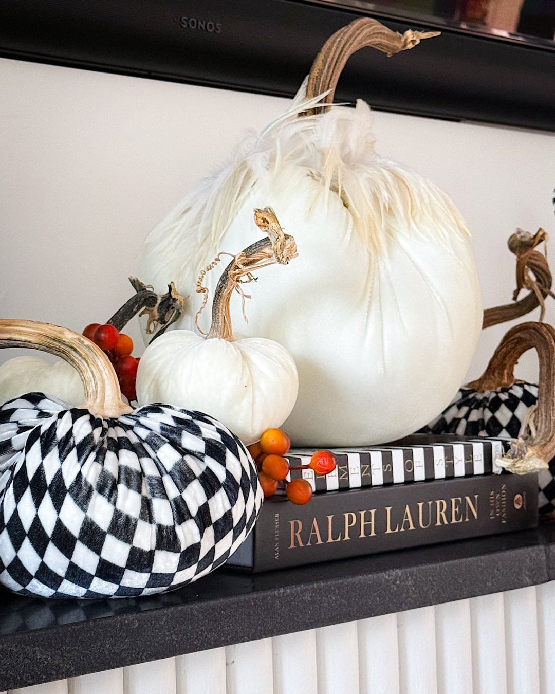 Halloween mantel decor ideas with white velvet pumpkins and black and white checkered pumpkins