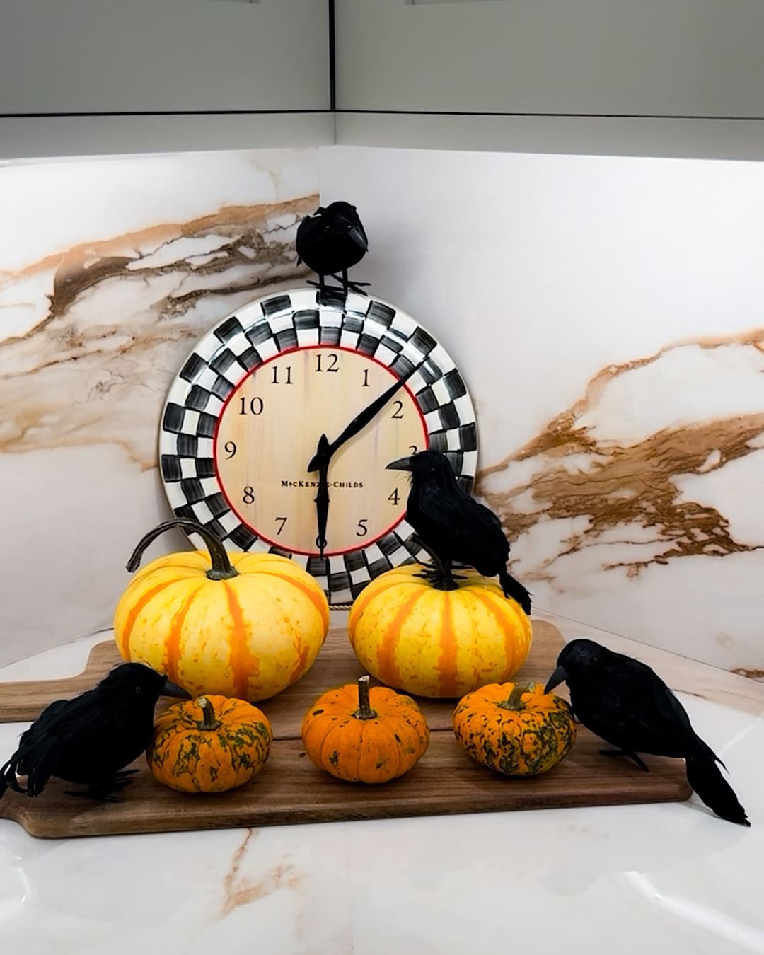 Kitchen Halloween decor ideas with pumpkins and black crows on a wooden board