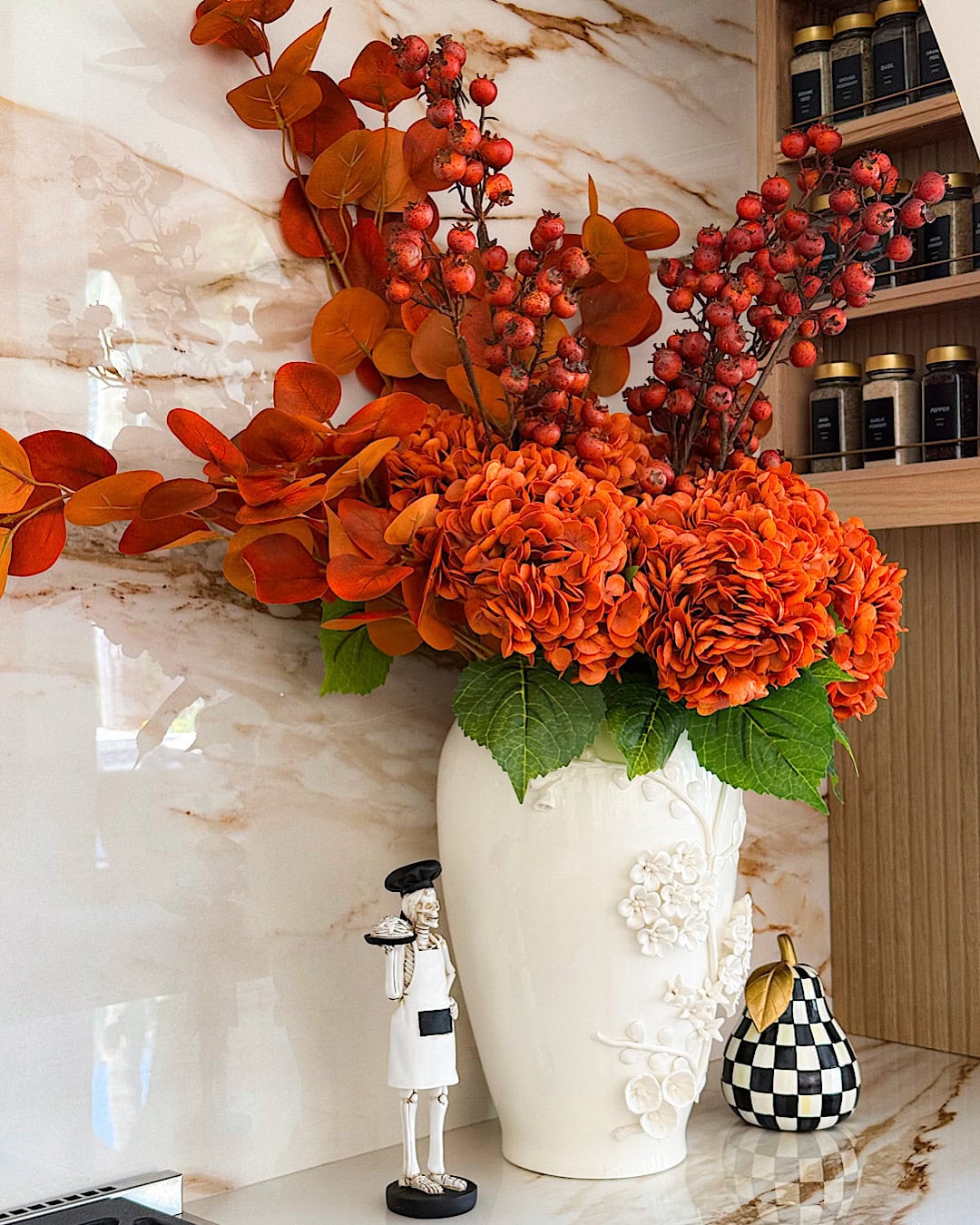 Spooky kitchen decor with a skeleton chef figurine next to a white vase